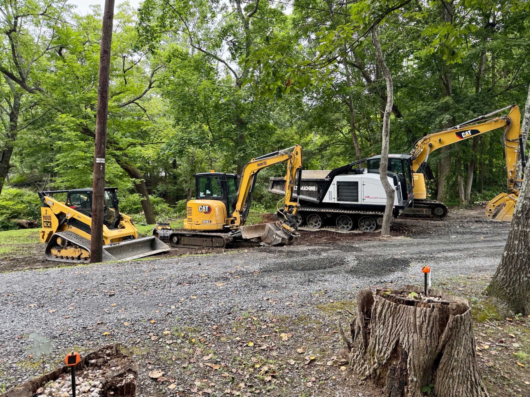 WoodEx crew and equipment lineup on a wooded job site