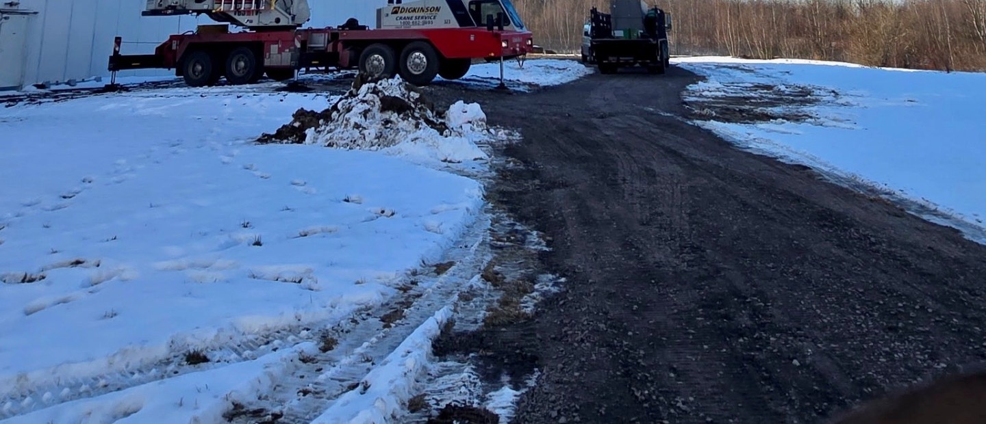 Crane and access road on a snowy commercial site
